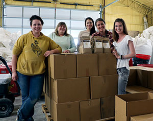 five people with a stack of boxes and some small bags on top