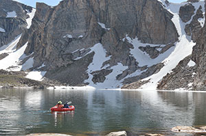 people boating in a mountain lake