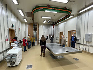 people in a large room with a large metal table