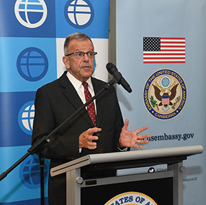 man speaking into a microphone at a podium