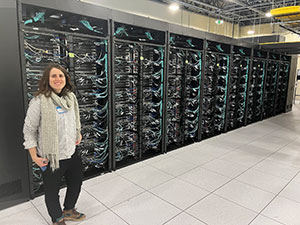 woman standing in front of a wall of servers