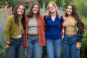 four women standing together outside