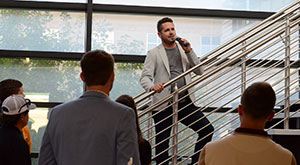 man on a staircase talking to a group of people