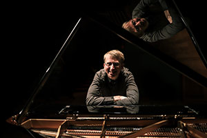 man leaning on a grand piano