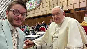 man posing with Pope Francis