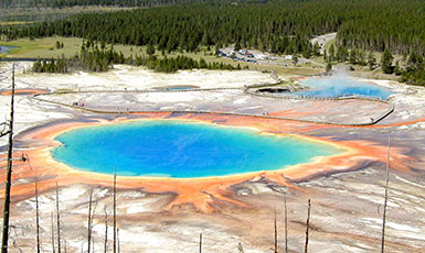 geothermal pool with many colors of deposits around it
