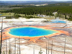geothermal pool with many colors of deposits around it