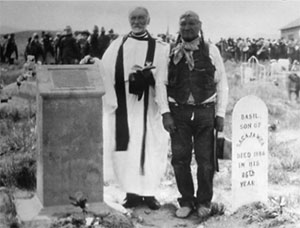 black and white photo of two people standing by gravestones