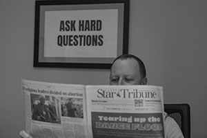 black and white photo of a person reading a newspaper