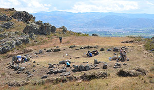 people working at a stone circle dig in mountains