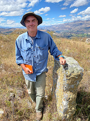 man leaning on an upright stone slab