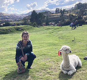 woman posing near an alpaca