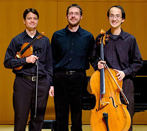 three people posing with musical instruments