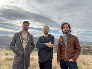 three people standing outside with the prairie in the background