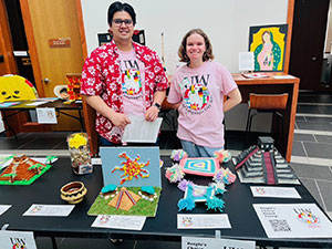 two people behind a table full of crafted items