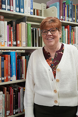 woman standing beside bookshelves