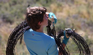 person carrying rolls of barbed wire