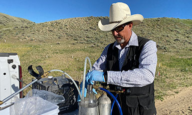 man working with cannisters on the back of a pickup truck