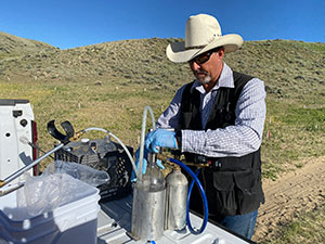 man working with cannisters on the back of a pickup truck