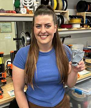 woman holding a 3d printed model of larynx
