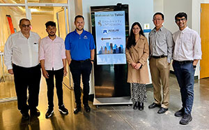 six people standing beside a sign indoors