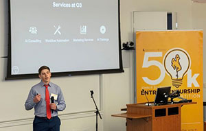 man standing in front of screen and beside podium