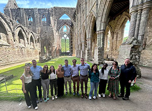 group of people posing in front of castle ruins