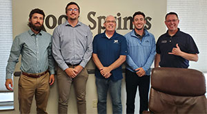 five men standing against a wall