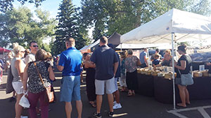 people beside a tent with food displayed for sale