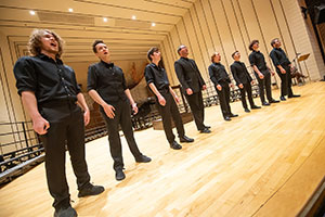 Row of men on stage singing