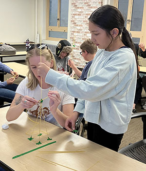 woman working with girl on project at a table