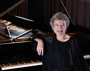 woman with arm propped on piano