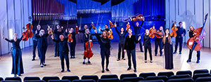 musicians standing on a stage, raising their instruements