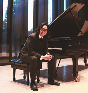 man posing at a grand piano