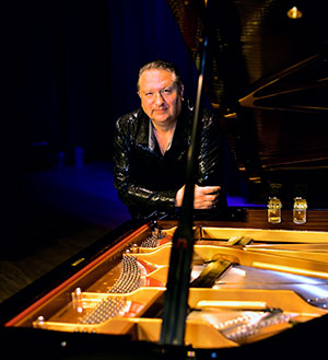 man leaning on a grand piano