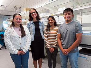 four people posing together in a lab