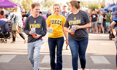 three students walking downtown during street fair
