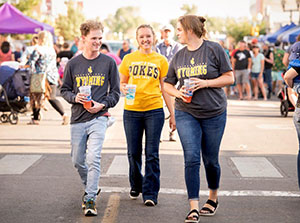 three students walking downtown during street fair