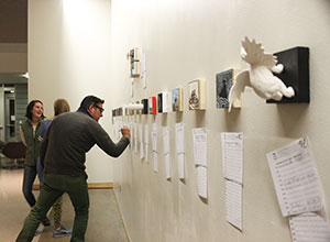 man examining art displayed on wall