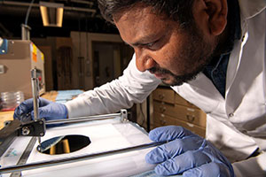 man leaning over lab instruments