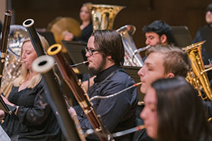 people playing wind instruments, with bassoonists in the foreground