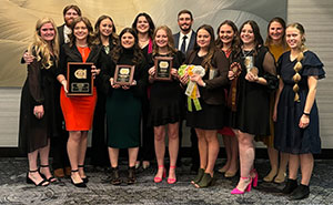 group of people posing together with plaques and prize ribbons