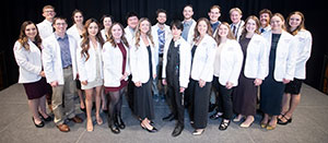 group of people posing in short white medical coats