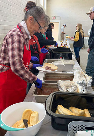 people serving food at a long table