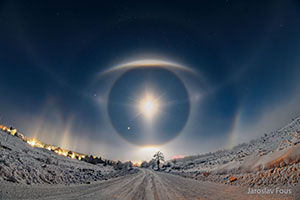 moon showing and reflecting through clouds of ice crystals