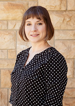 woman standing in front of a stone wall