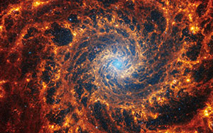 picture of red, orange and yellow swirling around a blue-white center, all on a black background