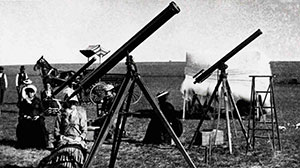 vintage black and white photo of people with telescopes on the prairie
