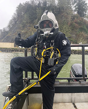 man wearing diving suit and helmet in a boat