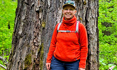 woman standing in front of a large tree